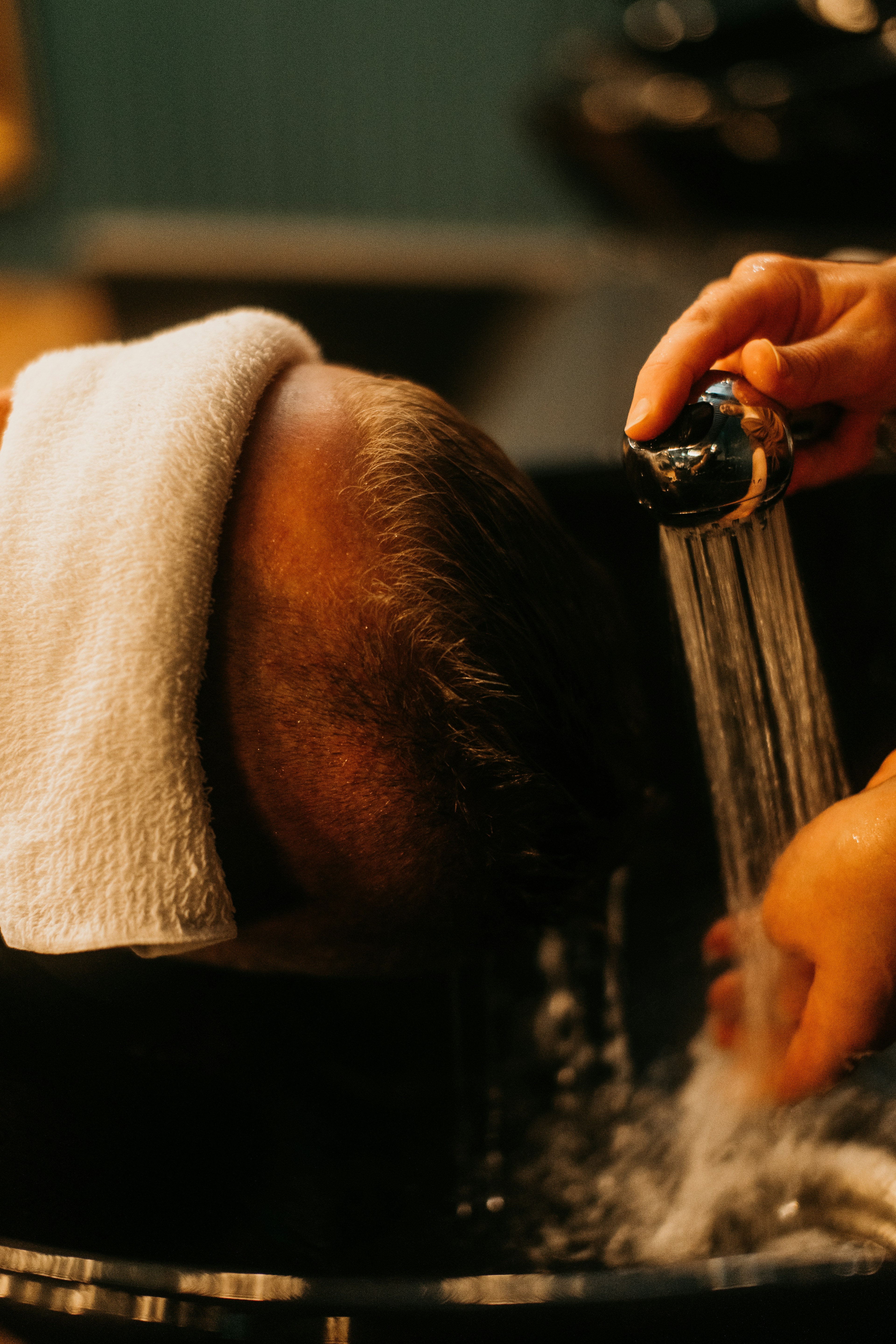 Warm water poured over the scalp at the basin